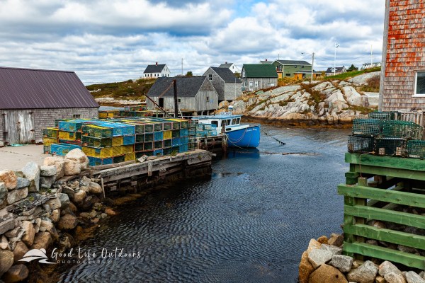A colorful view of a boat, lobster pots and buildings in Peggy's Cove, Nova Scotia in Canada.